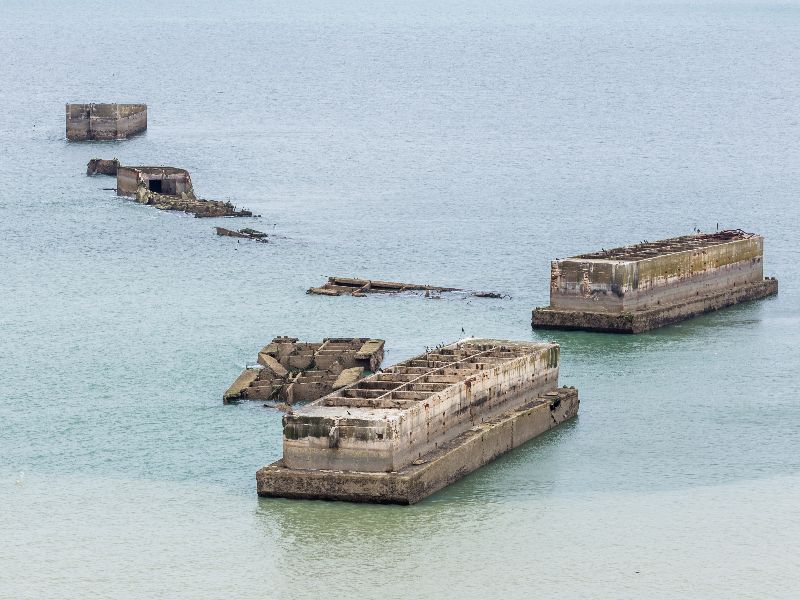 De overblijfselen van de Mulberry-haven zijn nog steeds zichtbaar voor de kust van Arromanches