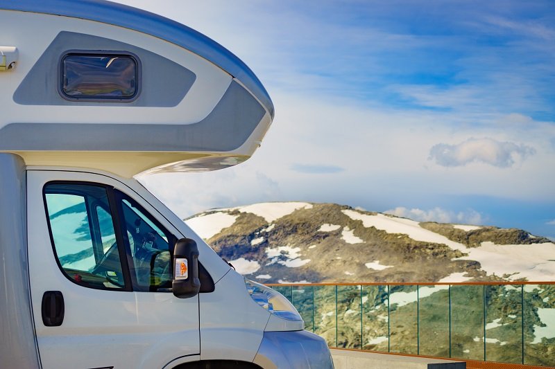 Een alkoofcamper met slaapgedeelte boven de cabine. 