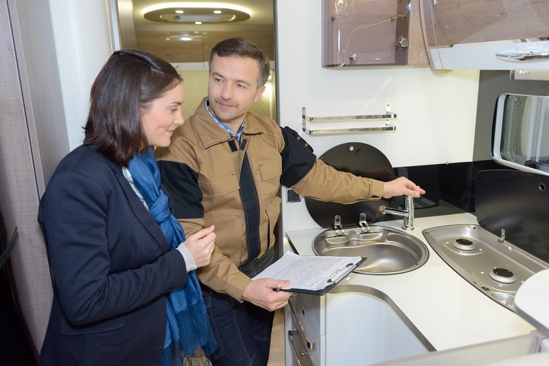 Man legt werking keuken in de camper uit. 