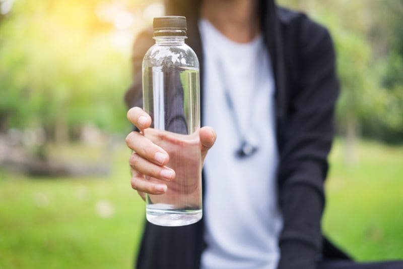 Flesje water in hand