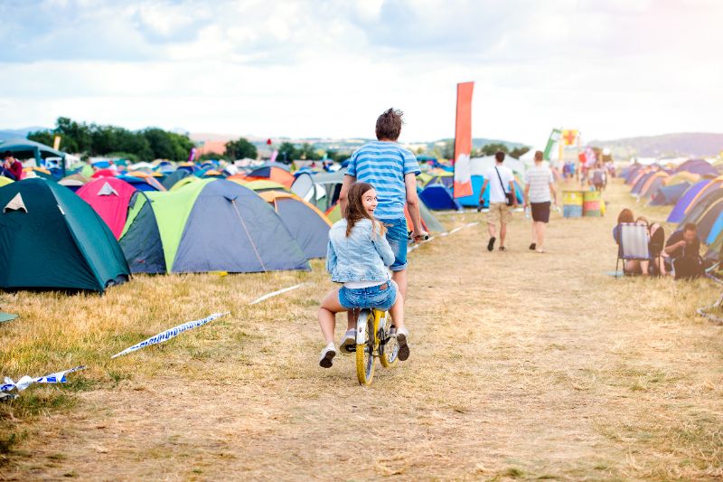 Twee mensen op een fiets op een festivalcamping