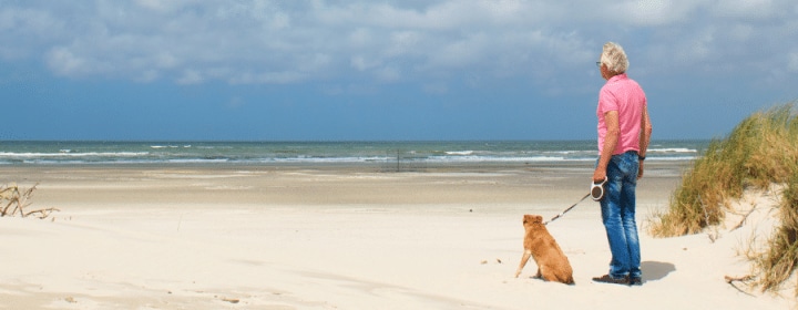 man met hond strand zeeland hondenstrand zeeland