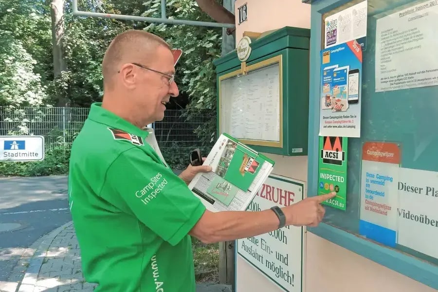 ACSI-inspecteur plakt ACSI Inspected-sticker op het raam