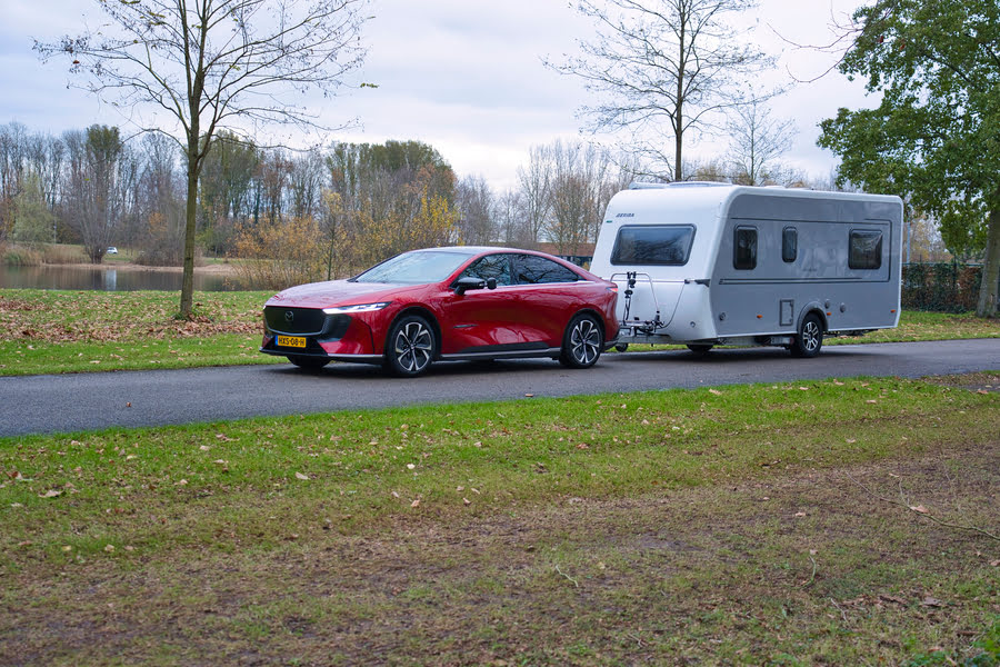 rode Mazda trekt een caravan