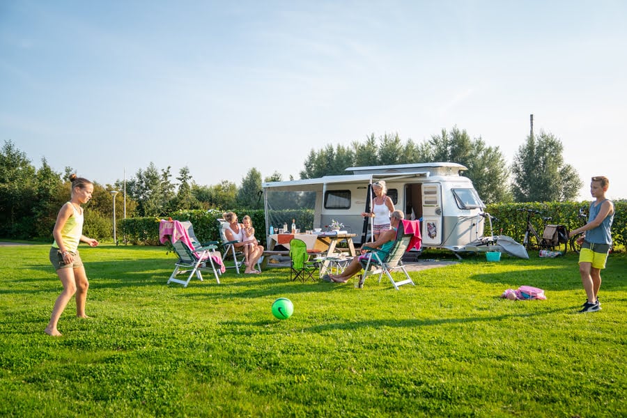 kinderen spelen buiten de caravan